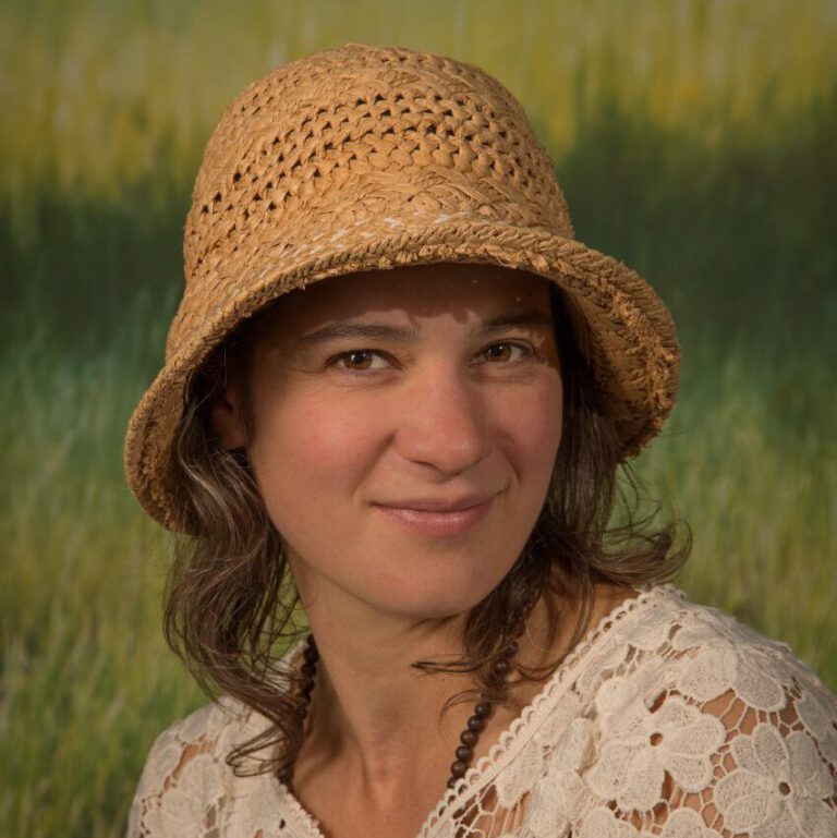 Mujer, sentada con un sombrero con media sonrisa